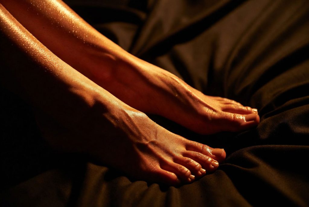 Piedi femminili sudati e odorosi appoggiati su tessuto scuro - fetish odore piedi